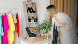 A woman standing in her closet picking outfits to wear for her photoshoot